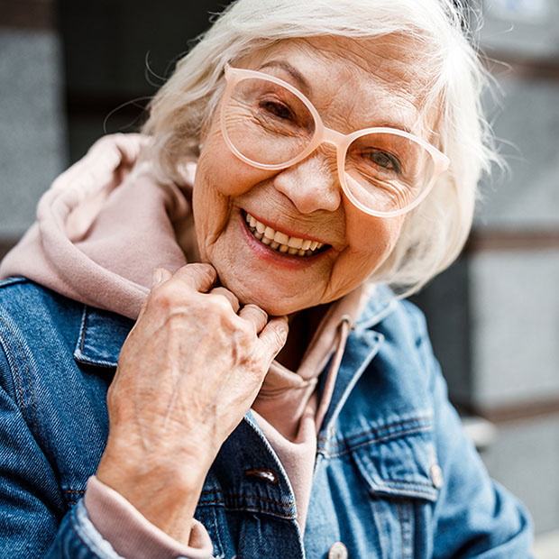 Smiling aged woman in jeans jacket stock photo