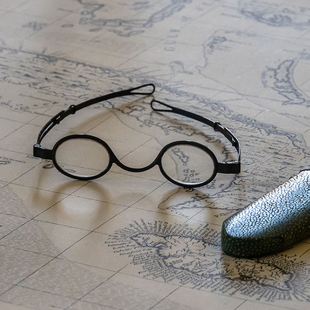 Pair of old glasses or spectacles on top of marine map