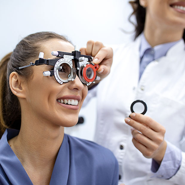 Ophthalmologist examining woman with optometrist trial frame. female patient to check vision in ophthalmological clinic